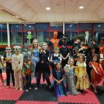 A group of children in Halloween fancy dress in a martial arts venue